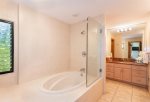 The remodeled master bathroom features two vanities with sinks and a oversized soaking tub with a shower
